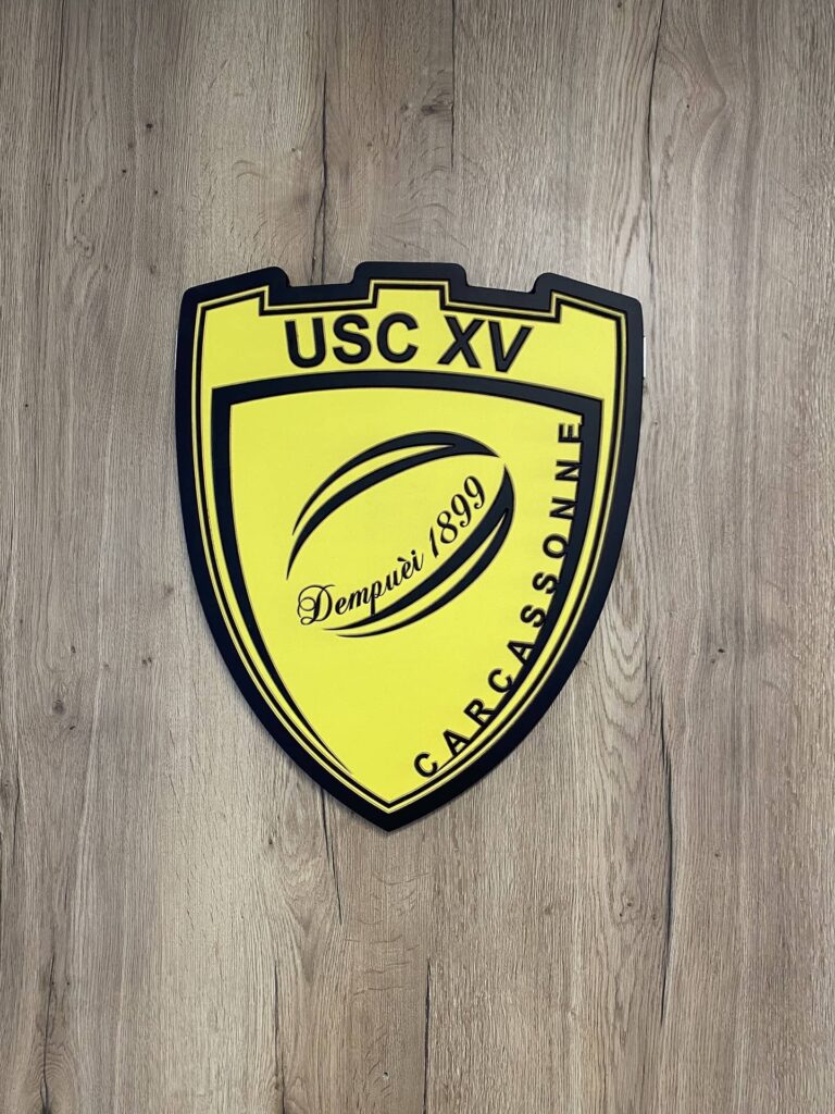 Blason du club de rugby de Carcassonne sur fond bois